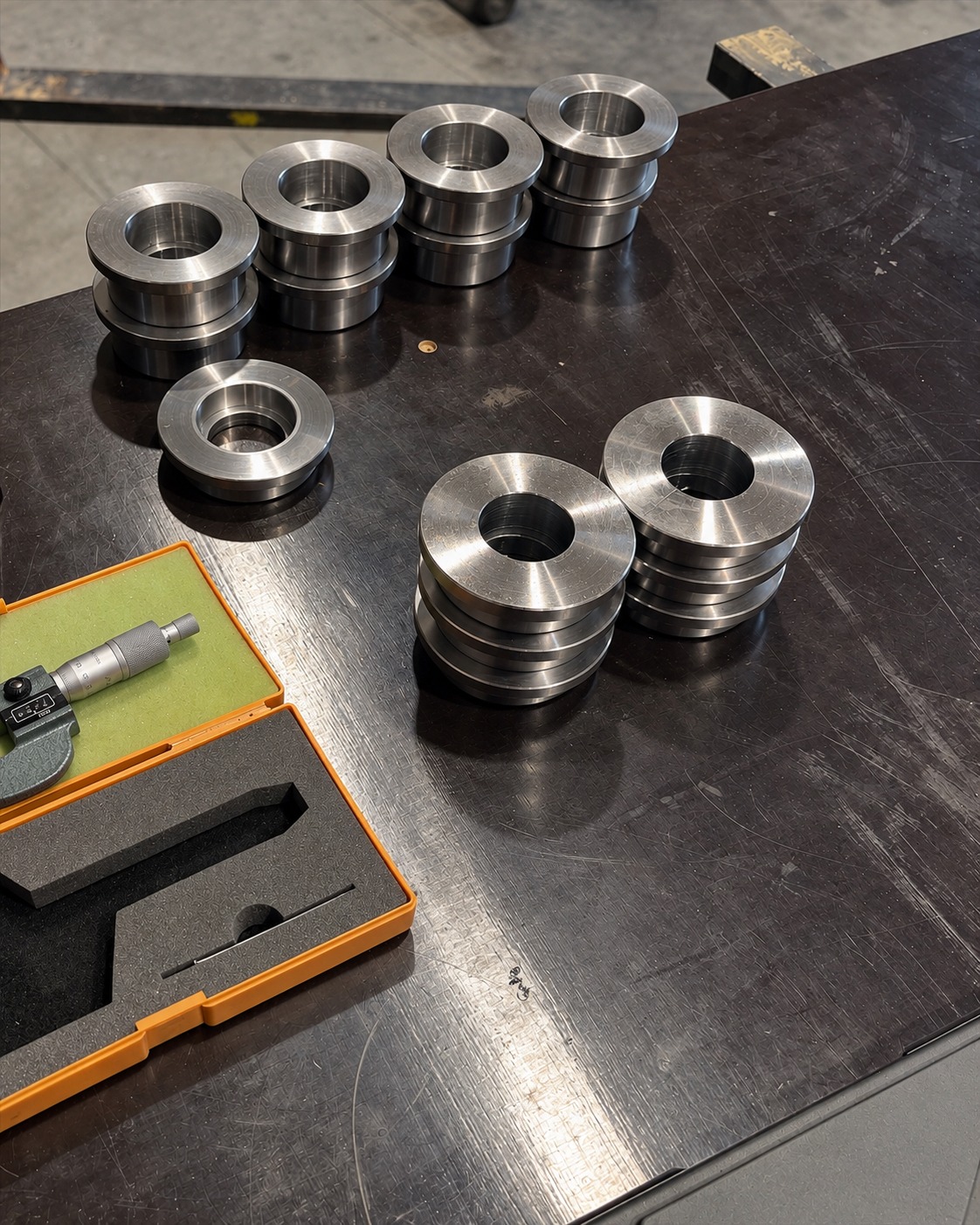 Gefrästes Metallbauteil mit technischer Zeichnung und Messwerkzeugen